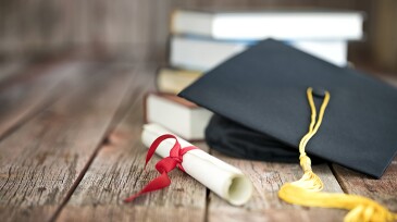 Graduation Cap and Diploma Concept on a Wood Background