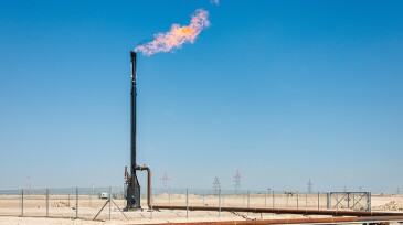 Burning flare stack in Middle Eastern Desert.