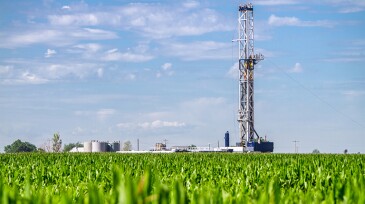 Close shot of a drilling Fracking Rig in a corn field.