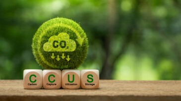 Carbon Capture, Utilization and Storage (CCUS) concept. Words CCUS on a wood block and Green earth with world map. Technology of CO2 capturing and store. Net zero target, limit global warming.
