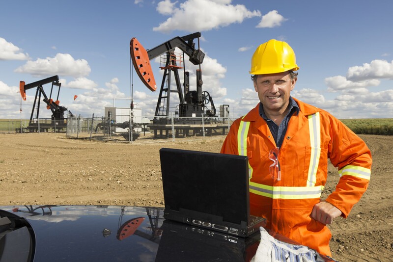Oilfield professional in front of a rig.