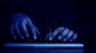 Cyberattack and internet crime, hacking and malware concepts. Digital binary code data numbers and secure lock icons on hacker' hands working with keyboard computer on dark blue tone background.