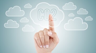 Woman's finger pushing a digital CO2 button shaped as cloud.