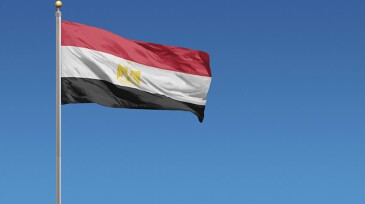 Flag of Egypt in front of a clear blue sky