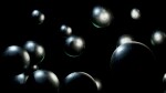 Stylized 3D render of dark metallic spheres floating in a black void. Ideal for technology, science, or abstract design projects.