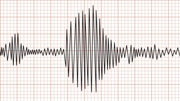 Earthquake seismic waves on seismogram graph paper.