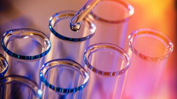 Test tube row. Concept of medical or science laboratory, liquid drop droplet with dropper in blue red tone background, close up, macro photography picture.