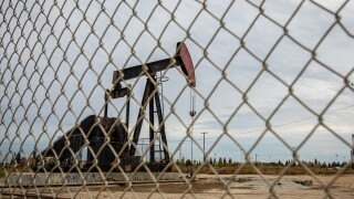 Oil Pump in Cloudy Rough Weather with Chain Link Fence