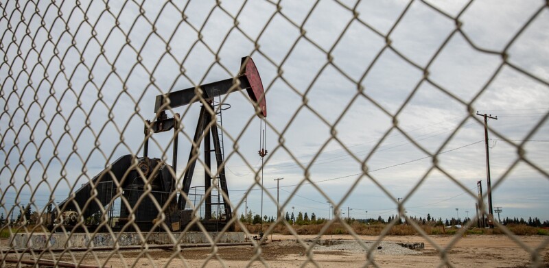 Oil Pump in Cloudy Rough Weather with Chain Link Fence