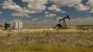 Oil well pump jack against dramatic cloudy sky