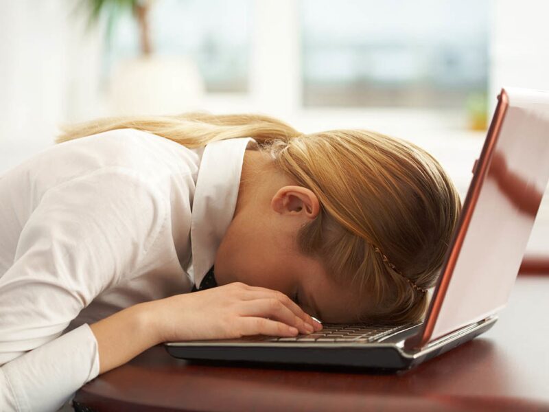 Woman sleeping face down on her laptop