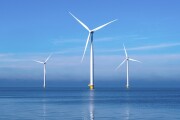 offshore windmill park with clouds and a blue sky