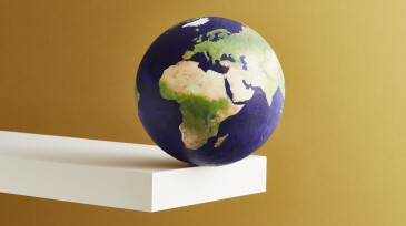 A world globe balanced on the edge of a shelf