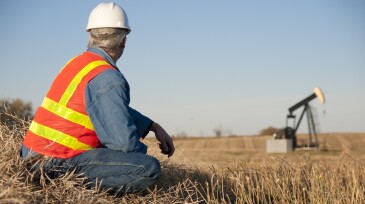 Oil Worker in Safety Gear at Well Pumpjack