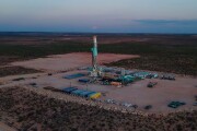 Drone view captures a stunning sunset over the Permian Basin, where a fracking drilling oil rig stands tall, symbolizing the intersection of nature and industry