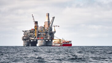Offshore platform and supply ship, sea wave blue clear sky