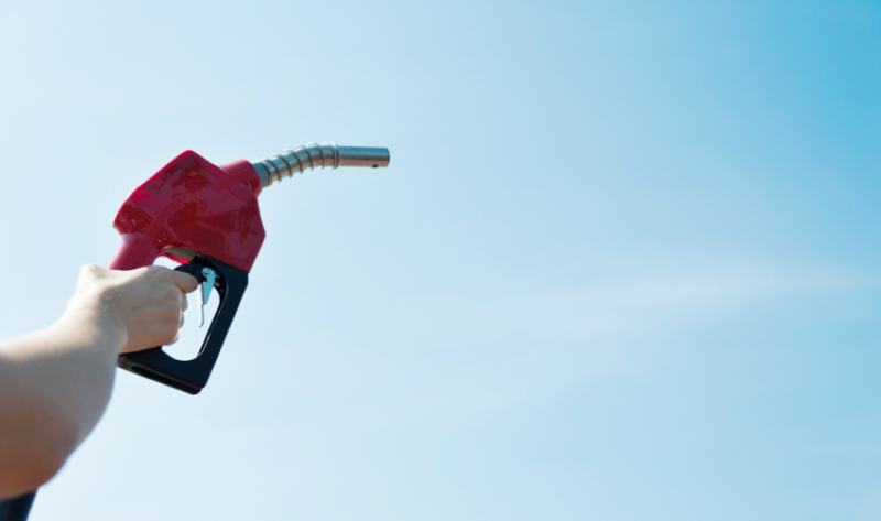 Hand holding nozzle of gas pump