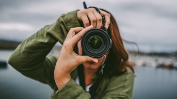 Young woman using DSLR camera