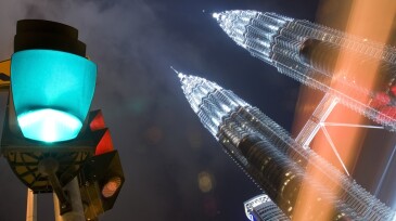 Kuala Lumpur at night with green light and Petronas Towers