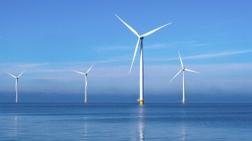 offshore windmill park with clouds and a blue sky