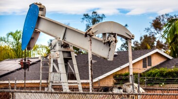 Oil Pumpjack overlooking the backyards of nearby homes in Long Beach, California.
