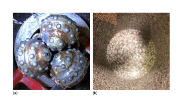Fig. 1—A tricone bit (a) and a rock sample (b) after drilling with a tricone bit. No visible fractures were observed at the bit/rock interface in any test.
